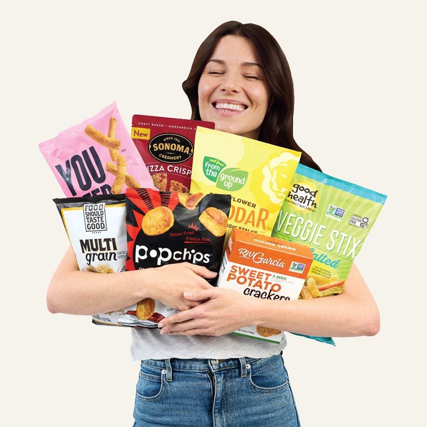 Woman holding seven assorted snacks