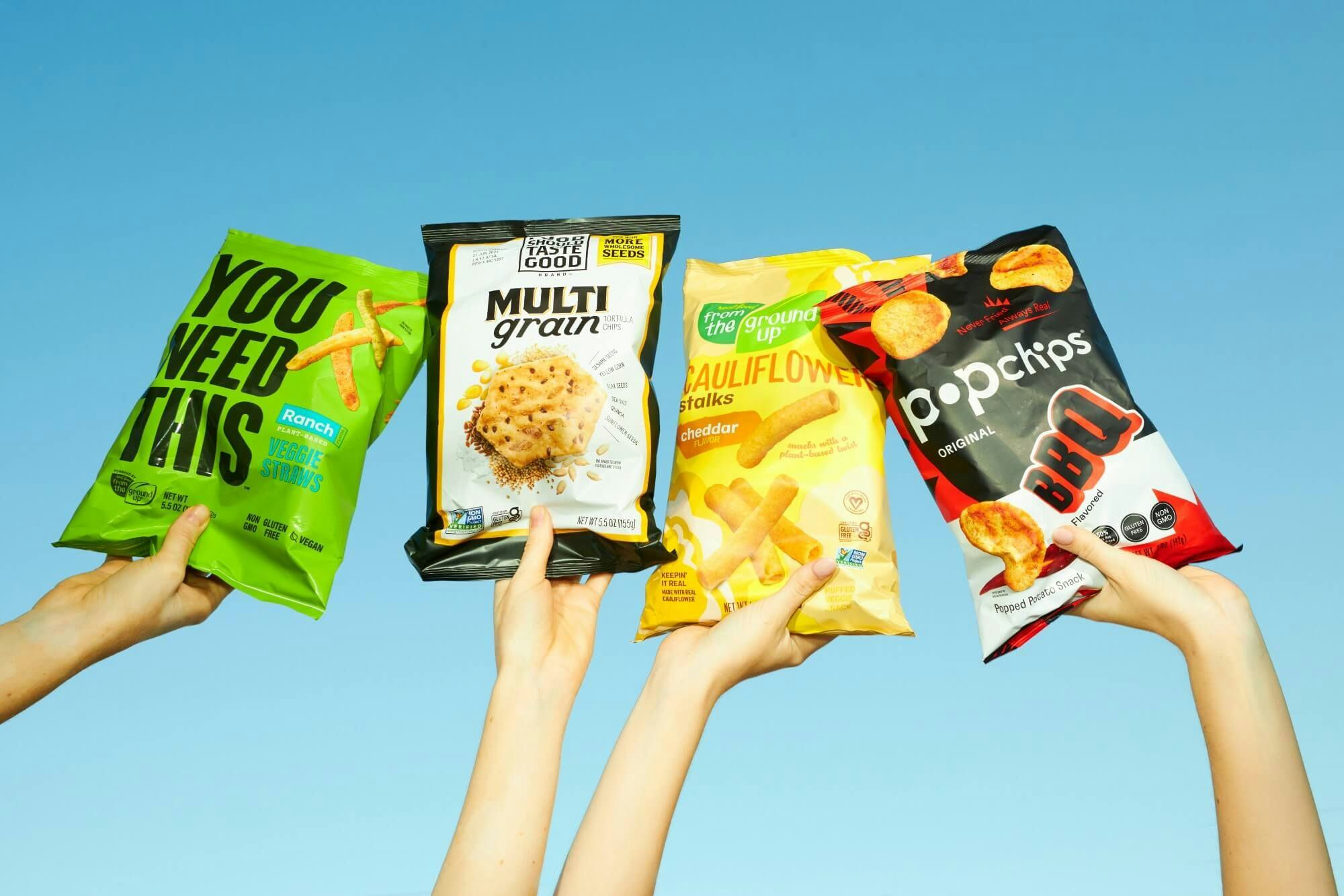Our Home snack brands held up into the air.